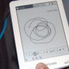 Samsung_E6_eReader_Natural_White_Front_Center_Left_Hand_Man_Model_Full_Body_Dandygadget_Portable_Media